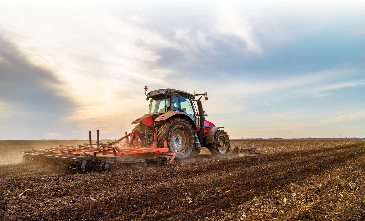 Tractor cultivating field at spring